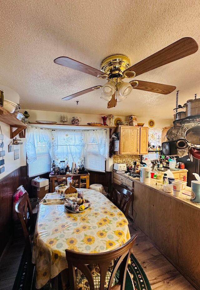 dining area with hardwood / wood-style floors, ceiling fan, and a textured ceiling