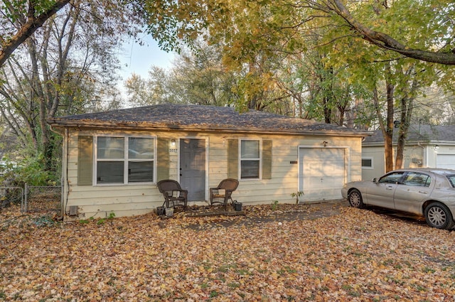 ranch-style house featuring an attached garage and fence