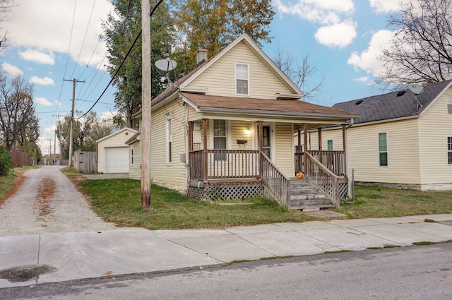 view of front of house featuring an outbuilding, a porch, a garage, driveway, and a front yard