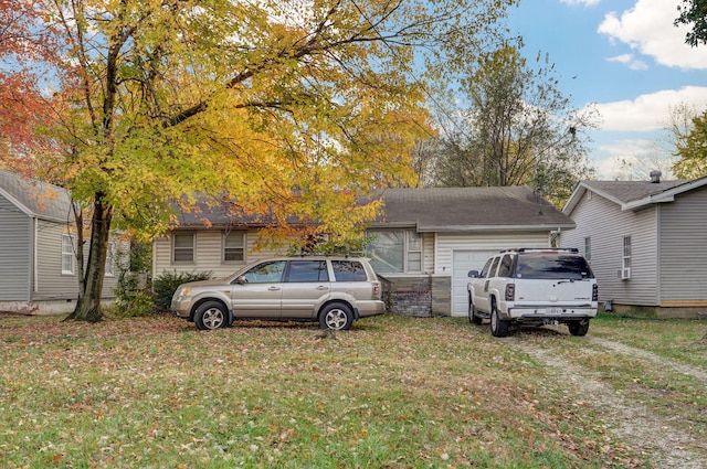 exterior space with an attached garage and a front lawn