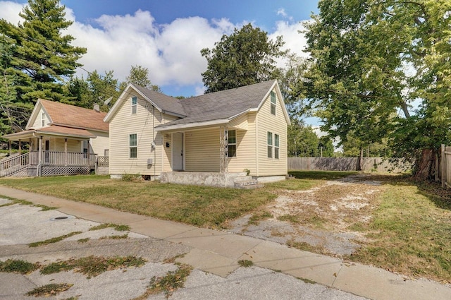 view of front of property with a porch, a front yard, and fence