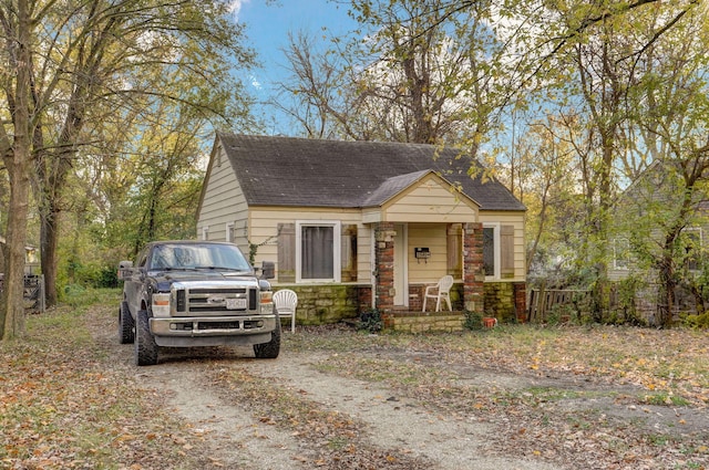 view of front of home featuring stone siding and roof with shingles