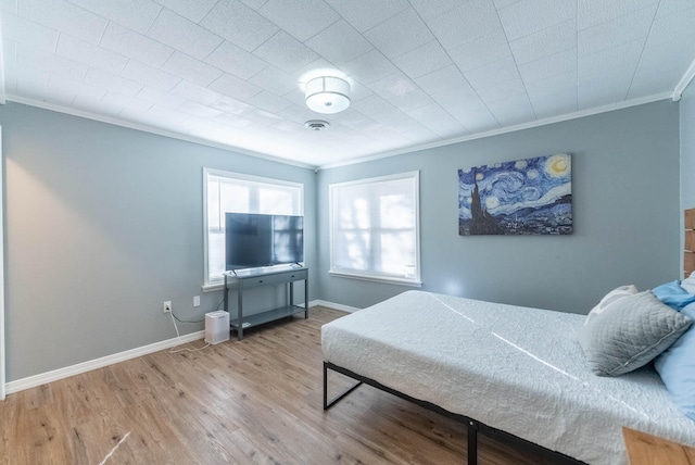 bedroom with crown molding and light hardwood / wood-style flooring