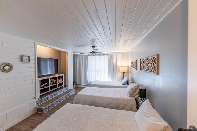 bedroom with hardwood / wood-style floors, ceiling fan, wood walls, and wood ceiling