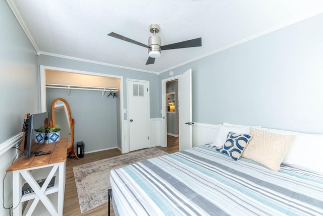 bedroom featuring ceiling fan, crown molding, light hardwood / wood-style flooring, and a closet