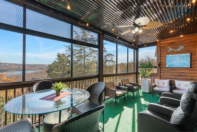 sunroom featuring a water view and ceiling fan