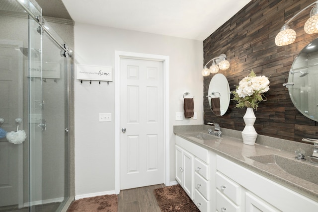 bathroom featuring wooden walls, vanity, wood-type flooring, and a shower with shower door