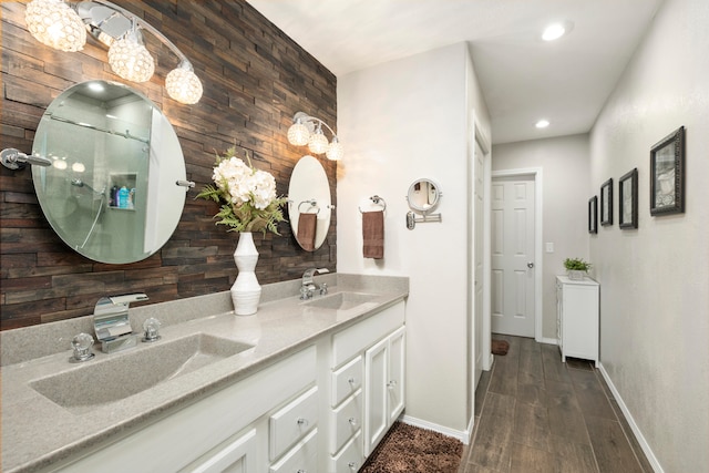 bathroom featuring hardwood / wood-style floors, vanity, wooden walls, and a mail area