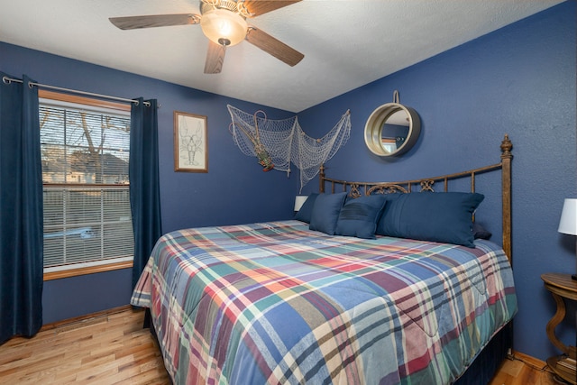 bedroom with light hardwood / wood-style floors and ceiling fan