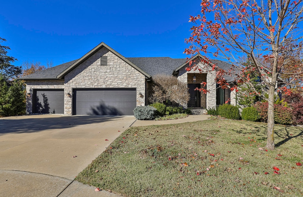 view of front of home with a front lawn and a garage