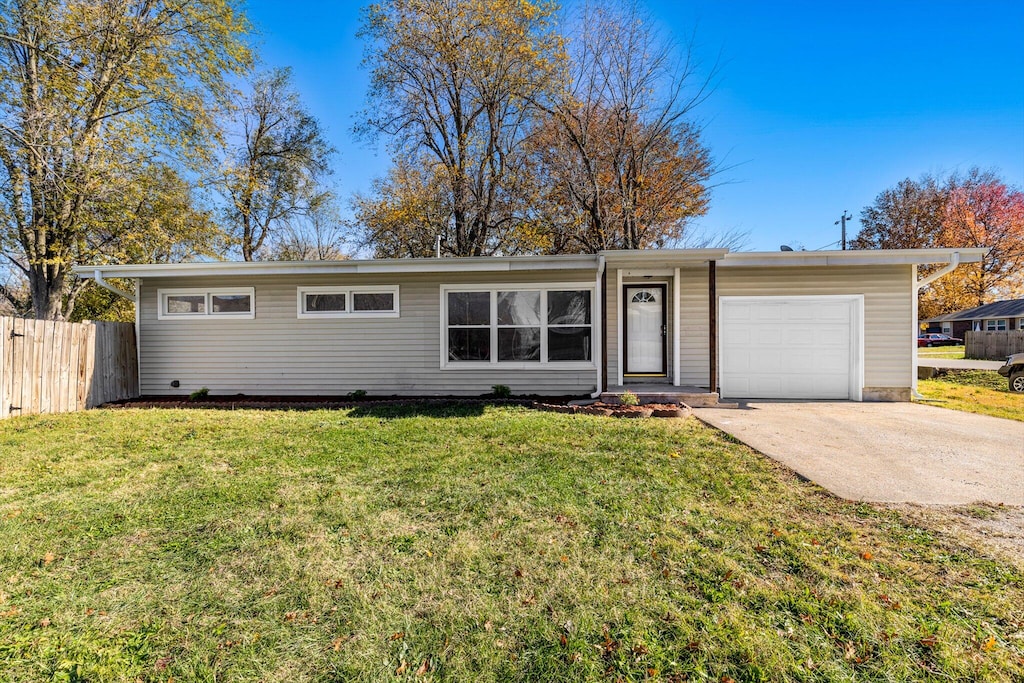 single story home featuring a front lawn and a garage