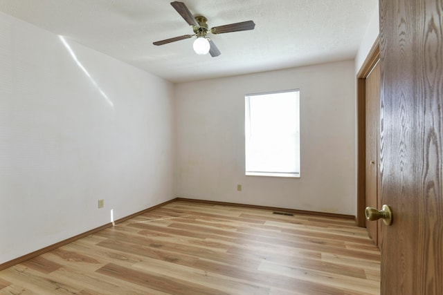 spare room featuring ceiling fan, a textured ceiling, and light wood-type flooring