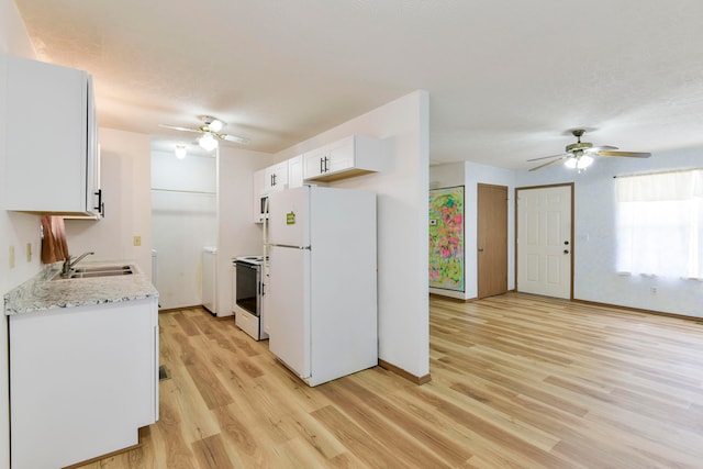 kitchen with white appliances, sink, light hardwood / wood-style flooring, white cabinets, and washer / clothes dryer