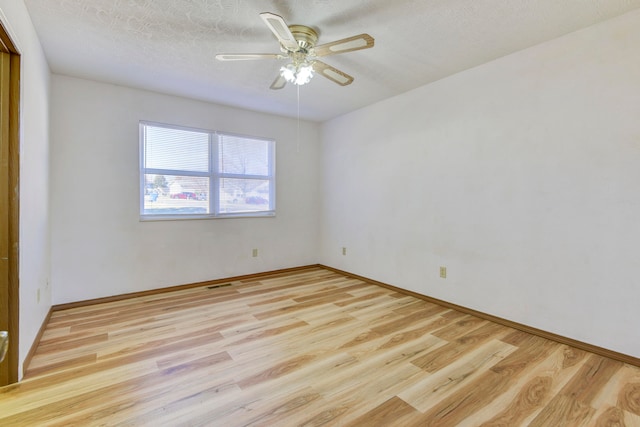 empty room featuring a textured ceiling, light hardwood / wood-style flooring, and ceiling fan