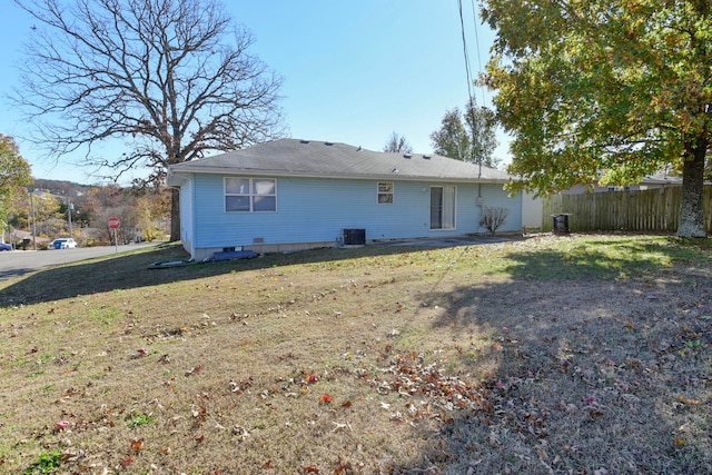 rear view of house with a lawn and central air condition unit