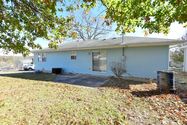 rear view of property with a lawn, a patio, and central AC unit