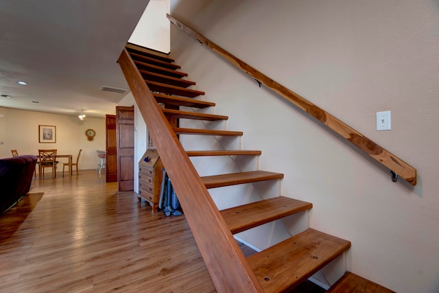 stairs featuring hardwood / wood-style floors