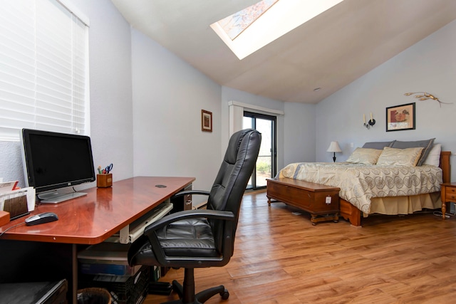 bedroom with wood-type flooring and lofted ceiling with skylight