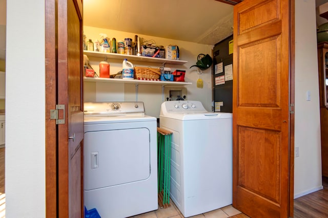 laundry area featuring separate washer and dryer and light hardwood / wood-style flooring