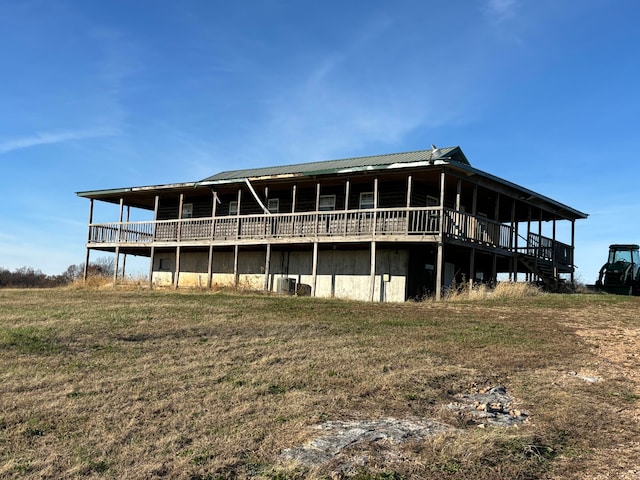 rear view of property with a wooden deck and a yard