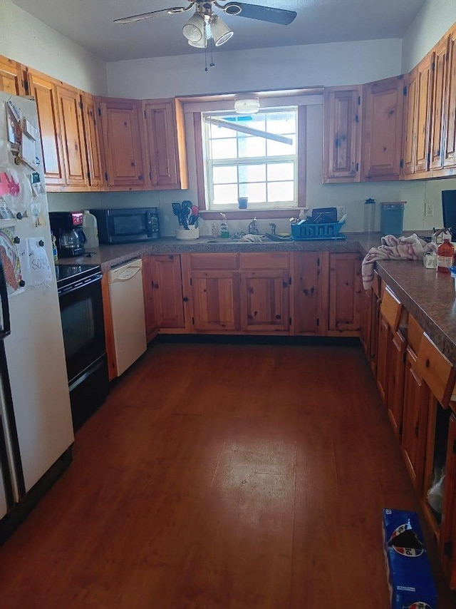 kitchen with a sink, a ceiling fan, black appliances, and dark wood-style flooring