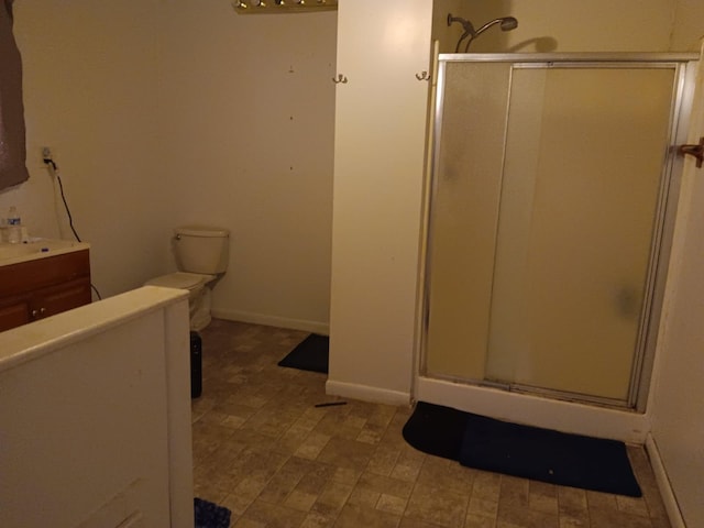 bathroom featuring vanity, baseboards, and a stall shower