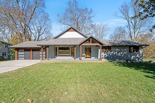 view of front of house featuring covered porch, a front yard, and a garage