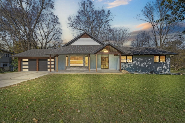 view of front of house featuring a lawn, a porch, and a garage