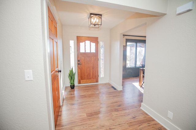 foyer featuring light hardwood / wood-style floors and an inviting chandelier