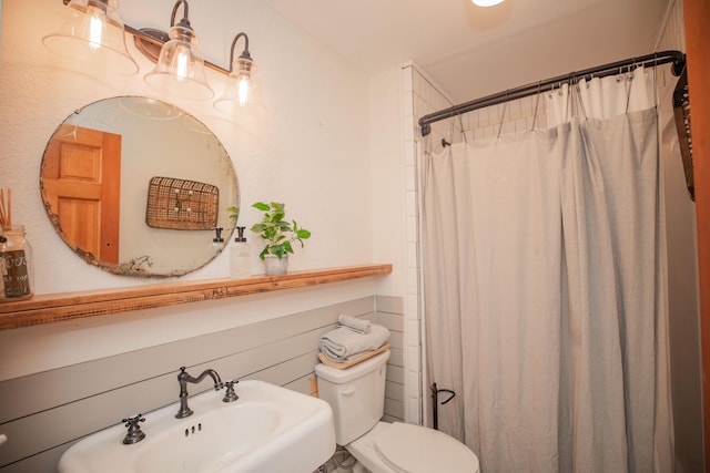 bathroom featuring a shower with curtain, toilet, and sink