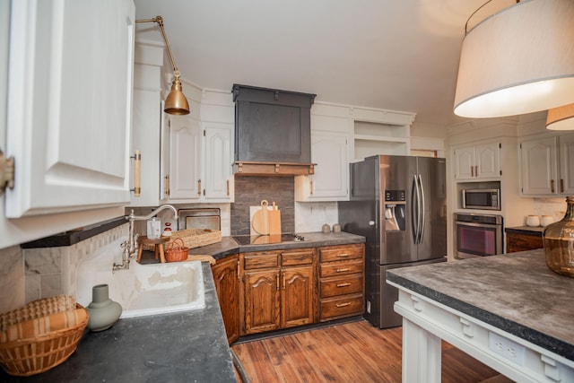 kitchen with white cabinets, sink, light hardwood / wood-style floors, custom range hood, and stainless steel appliances