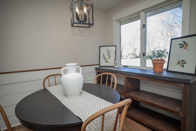 dining area with hardwood / wood-style floors and an inviting chandelier