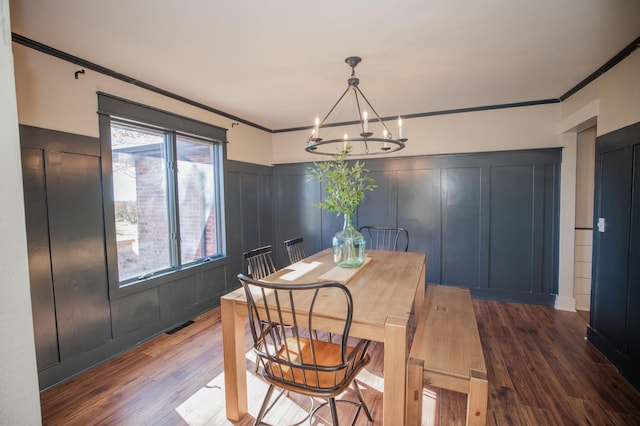 dining space featuring ornamental molding, dark hardwood / wood-style flooring, and a notable chandelier