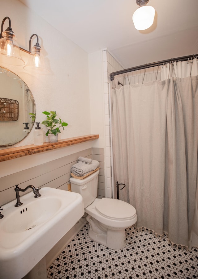 bathroom with tile patterned flooring, a shower with curtain, and toilet