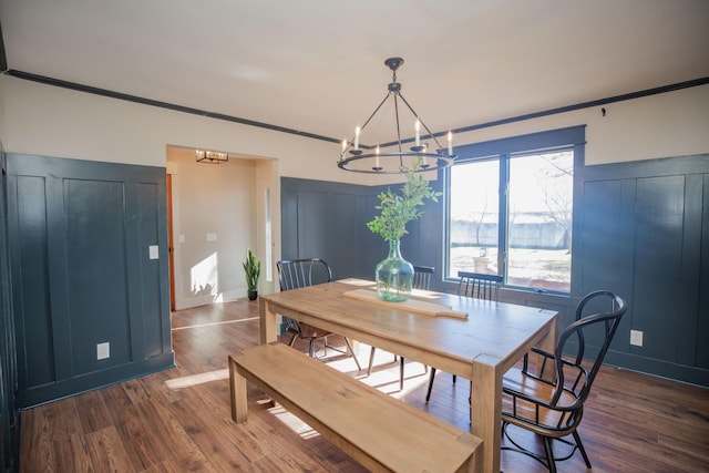 dining space featuring crown molding, dark hardwood / wood-style flooring, and a notable chandelier