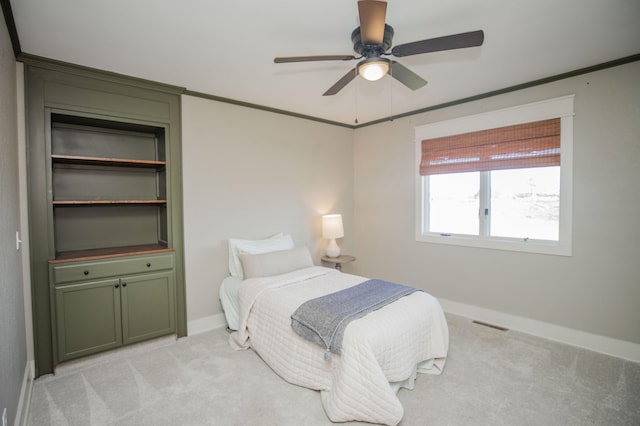 carpeted bedroom with ceiling fan and ornamental molding