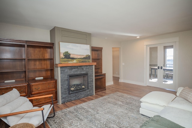 living room featuring a fireplace, french doors, and hardwood / wood-style floors