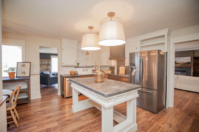 kitchen with decorative backsplash, hardwood / wood-style floors, custom range hood, and appliances with stainless steel finishes