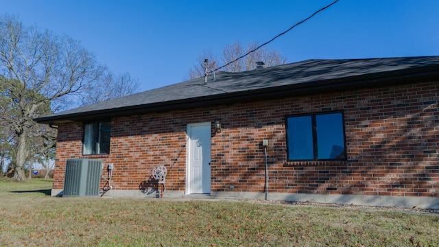 rear view of house featuring a yard and central AC unit