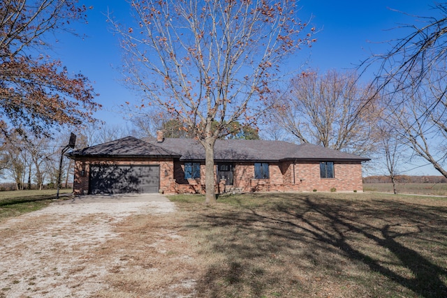 ranch-style home featuring a garage and a front lawn