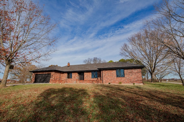 ranch-style house featuring a front lawn and a garage