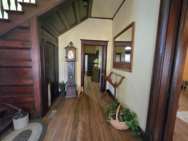 hallway featuring hardwood / wood-style floors and vaulted ceiling