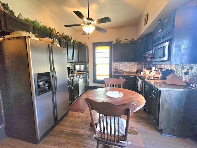 kitchen featuring dark hardwood / wood-style flooring, tasteful backsplash, ventilation hood, stainless steel appliances, and ceiling fan