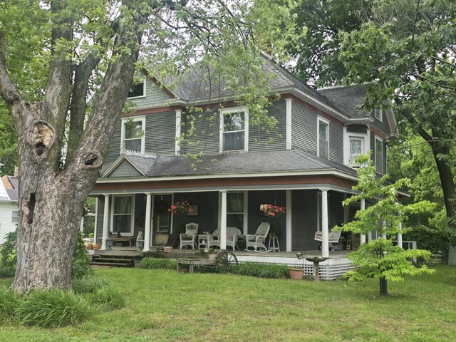 106 N Main St, Greenfield, MO 65661 - back of property featuring covered porch, a shingled roof, and a lawn