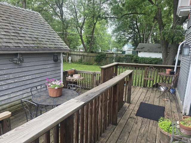 106 N Main St, Greenfield, MO 65661 - wooden deck featuring outdoor dining space and an outdoor structure
