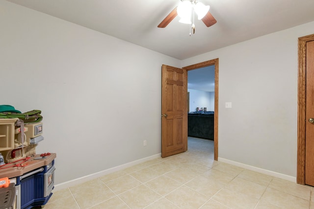 tiled spare room with ceiling fan