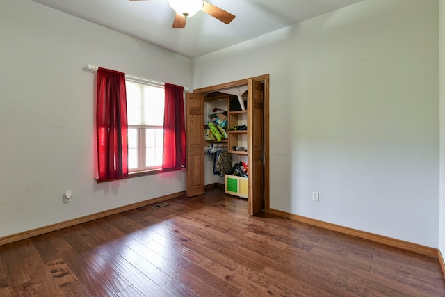 unfurnished room featuring ceiling fan and dark wood-type flooring