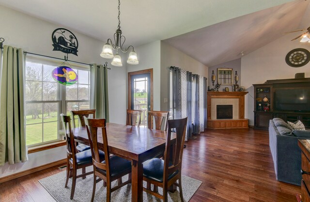 dining room with ceiling fan with notable chandelier, dark hardwood / wood-style flooring, and lofted ceiling