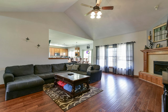 living room featuring a fireplace, dark hardwood / wood-style flooring, high vaulted ceiling, and ceiling fan