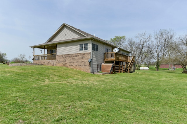 rear view of property with a yard and a deck